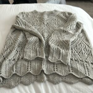 Beautifully knitted sweater events scalloped edge details in sleeves and seam.